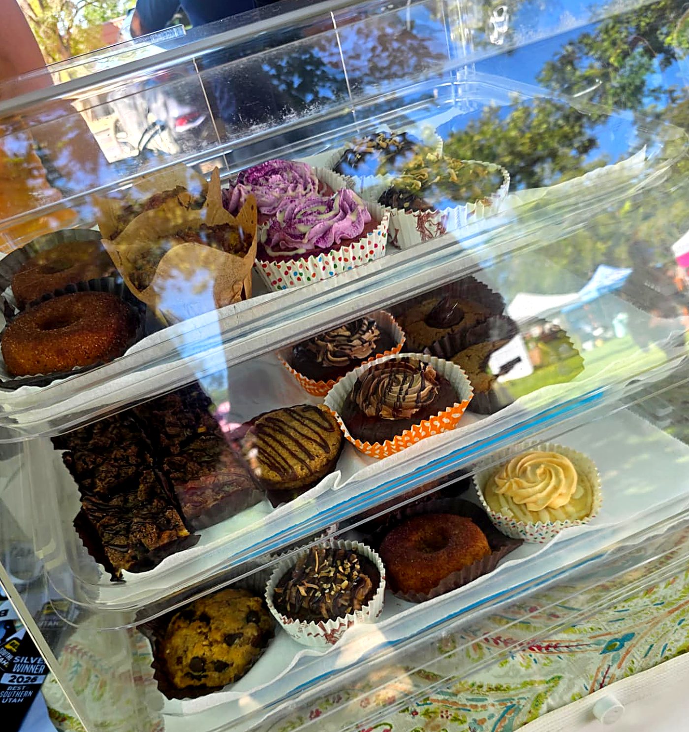 A three-tier display case of keto cupcakes, brownies and donuts